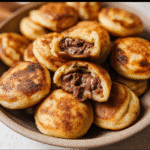 How to Make Fluffy Nutella Pancake Balls (With or Without a Special Pan!) 11 Mini pancake balls filled with Nutella on a ceramic plate